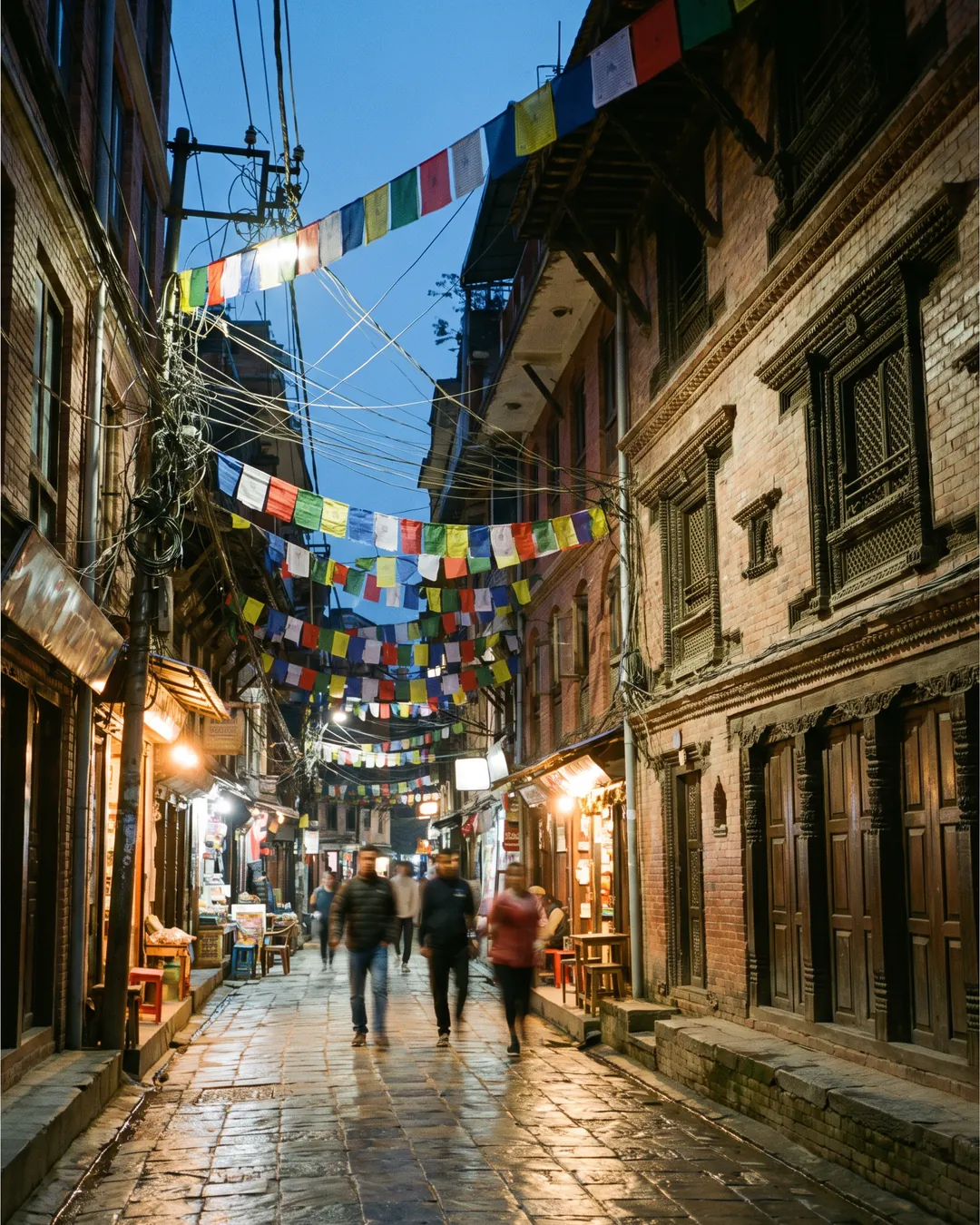 A lane in Thamel at dusk under prayer flags